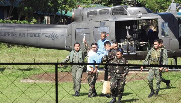 Malaysian seaman Abdurahim bin Sumas (in blue) is carried by military personnel to a waiting helicopter at a military hospital in Jolo town, Sulu province in southern island of Mindanao, yesterday, to be transported to Zamboanga City, after he and another Malaysian were rescued in Sulu island. Tayudin Anjut and Abdurahim bin Sumas, the two ailing Malaysian seamen held hostage by Filipino militants for eight months, were found yesterday aboard a boat adrift off the southern Philippines, the local military said.