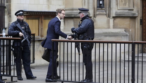 British Member of Parliament Tobias Ellwood shakes hands with an armed police officer as he arrives at the Houses of Parliament, following a recent attack in Westminster, London.