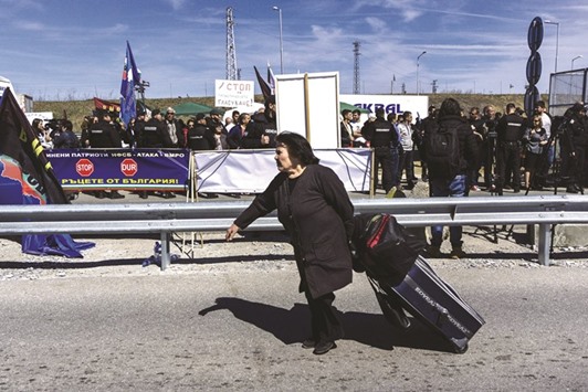 A woman pulls her suitcase as she crosses the Bulgaria-Turkey border on foot during a rally of Bulgarian nationalists, at the Kapitan-Andreevo checkpoint, aimed at preventing ethnic Turks with Bulgarian passports from crossing to vote in the countryu2019s general elections.