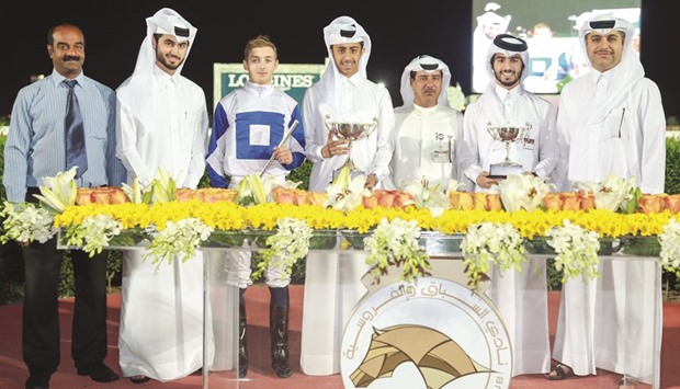 Qatar Racing and Equestrian Club vice chief steward Abdulla Rashid al-Kubaisi with the winners of the Umm Al Afai Cup after Pleaseletmewin won the feature at QREC on Thursday. PICTURE: Juhaim