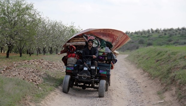 A Syrian man flees with his belongings from the village of Rahbet Khattab in the Hama province