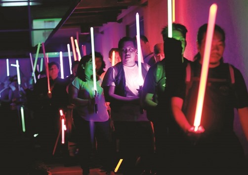 Star Wars enthusiasts raise their light sabers as they participate in the annual Earth Hour, an hour of lights out to raise awareness on climate change, in Taguig city, Metro Manila yesterday.