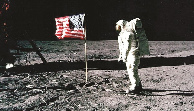 Buzz Aldrin standing by the US flag planted on the surface of the moon.