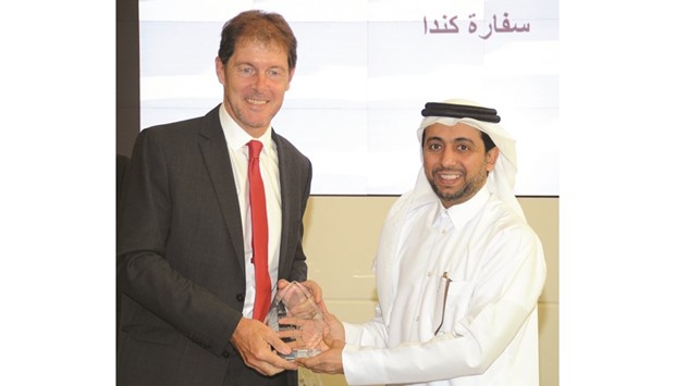The Canadian ambassador receiving the award from the QU president.
