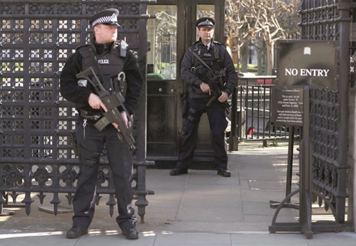 Armed police officers stand at the Carriage Gates entrance to the Houses of Parliament.