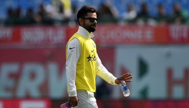 India's Virat Kohli walks back to the pavillion after a drink break during the first day of the fourth and last cricket Test match between India and Australia at the Himachal Pradesh Cricket Association Stadium in Dharamsala. AFP
