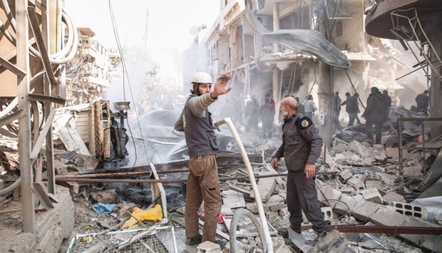Syrian civil defence volunteers, known as the White Helmets, extinguish a fire following reported ai