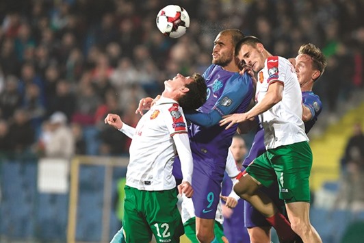 Netherlandu2019s Bas Dost (centre), Bulgariau2019s Bozhidar Kraev (left) and Bozhidar Chorbadzhiyski go for a header during the World Cup qualifying match in Sofia on Saturday night. (AFP)