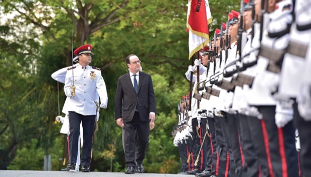 French President Francois Hollande reviews a guard of honour during a welcoming ceremony at the Istana presidential palace in Singapore yesterday.