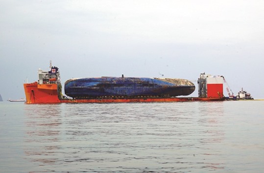 A photo by the Maritime Ministry shows the wreck of the Sewol ferry placed onto a submersible vessel off the coast of the island of Jindo, South Korea.