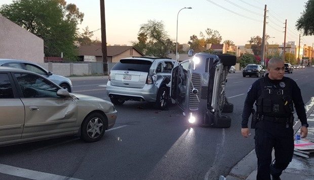 A self-driven Volvo SUV owned and operated by Uber Technologies Inc. is flipped on its side after a collision yesterday in Tempe, Arizona. Reuters