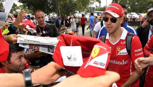 Ferrari's German driver Sebastian Vettel signs autographs for fans before the Formula One Australian Grand Prix in Melbourne.
