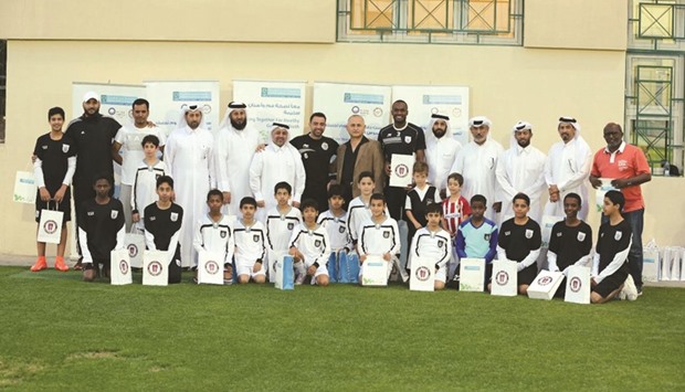 Dr al-Darwish and other officials with football players and students during an event held at the Al Sadd Sports Club to mark World Oral Health Day.