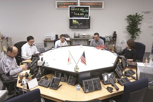 Currency traders work in the dealing room of a foreign exchange brokerage in Tokyo. Rising Japanese real-interest rates, the yenu2019s haven status from global political  uncertainty and technical signals monitored by foreign exchange traders have helped the currency rebound 7% from December lows against the dollar.