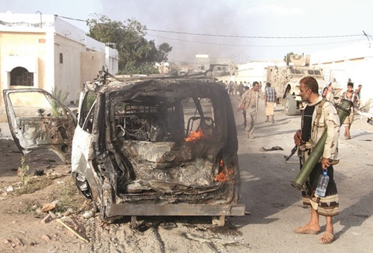A Yemeni man looks at a burning vehicle following a reported suicide car bombing in Huta, the capital of the southern province of Lahj, yesterday.