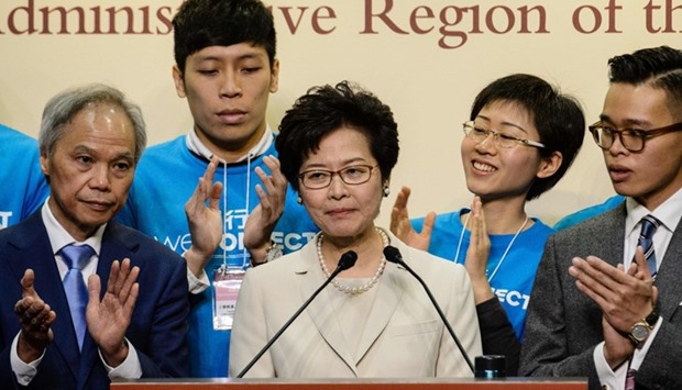 Hong Kong's new chief executive Carrie Lam (C) reacts at a press conference after she won the Hong Kong chief executive election