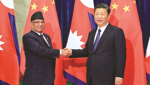 Chinese President Xi Jinping, right, shakes hands with Nepalese Prime Minister Pushpa Kamal Dahal at the Great Hall of the People in Beijing yesterday.