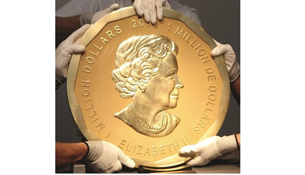 This picture taken in Vienna, Austria on June 25, 2010 shows experts of an Austrian art forwarding company holding one of the worldu2019s largest gold coins, a 2007 C$1,000,000 u2018Big Maple Leafu2019. An identical coin was stolen from Berlinu2019s Bode Museum yesterday.