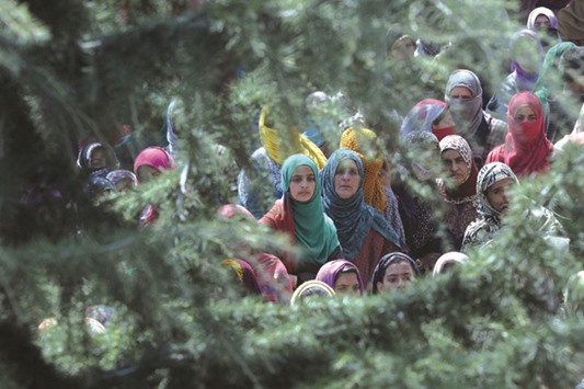 Kashmiri villagers watch the funeral procession of suspected rebel Shahbaz Shafi, also known as Rayees Kachroo, at Belov village in Pulwama, south of Srinagar, yesterday.