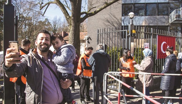 Hussain Saregul, a Turkish national living in Germany, takes a selfie with his son Ali Deniz after voting at a polling station at the Turkish consulate in Berlin.