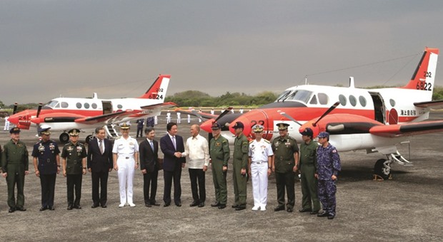 Philippine National Defence Secretary Delfin Lorenzana (centre, right) greets Japan State Minister of Defence Kenji Wakamiya upon arrival of the two units of Beechcraft TC-90 training aircraft from Japanese Ministry of Defence (JMOD), during a transfer ceremony of the aircrafts to the Philippine Navy at the Naval Air Group (NAG) headquarters in Sangley Point, Cavite city, south of Manila, yesterday.