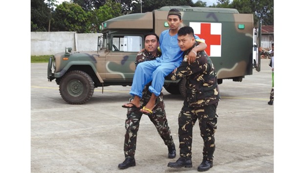 Filipino soldiers carry one of three rescued Malaysian hostages to a waiting aircraft at the airport in Jolo town, Sulu province, in the southern island of Mindanao, yesterday.