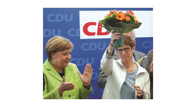 Merkel congratulates Saarland state premier Kramp-Karrenbauer during a party leadership meeting in Berlin.
