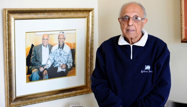 Ahmed Kathrada posing next to a picture of himself with Nelson Mandela in his house in Johannesburg. July 16, 2012 file picture.