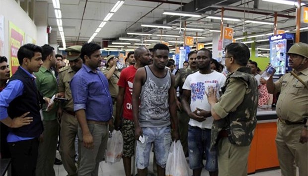 Police and onlookers surround African nationals at a shopping mall in Greater Noida.