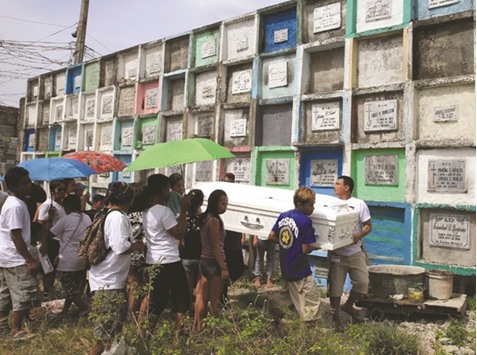 Loved ones and mourners pay their last respects to Arjay Suldao, 16, who according to the local media was a victim of unknown assailants related to the drug war, during his funeral at a cemetery in Navotas city, Metro Manila, yesterday.