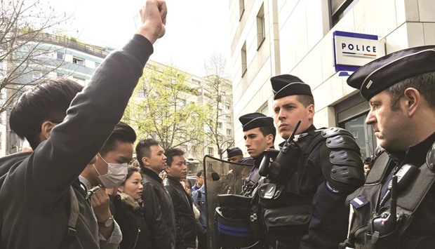 French police face off with members of the Chinese community during a protest outside a police station in Paris, following the shooting death of a Chinese man at his Paris home on Sunday, triggering riots in the French capital.