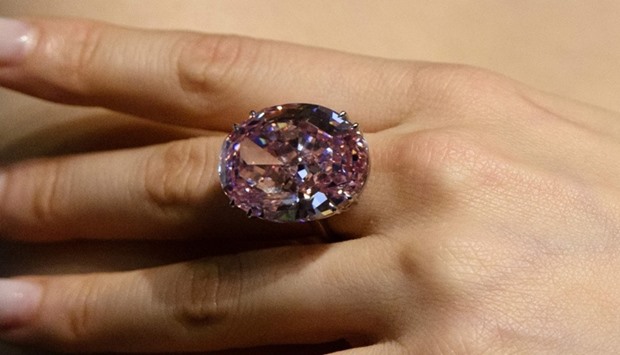 A model poses with a 59.60-carat oval mixed-cut pink diamond, known as 'The Pink Star'