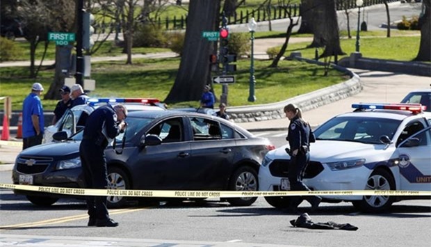 Capitol Hill police inspect a car whose driver struck a Capitol Police cruiser and then tried to run over officers, near the US Capitol in Washington on Wednesday.