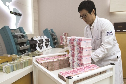 An employee arranges yuan banknotes at the Korea Exchange Bank headquarters in Seoul. The yuan has moved the least versus the dollar in the first quarter among non-pegged major currencies after the Canadian dollar.