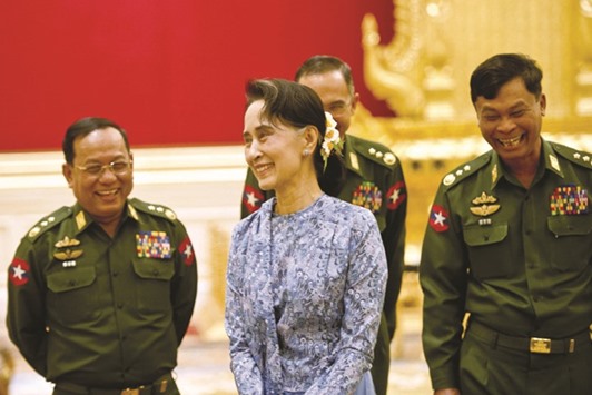 A March 30, 2016, file photo of Aung San Suu Kyi and military generals share a lighter moment during the handover ceremony in Naypyidaw.