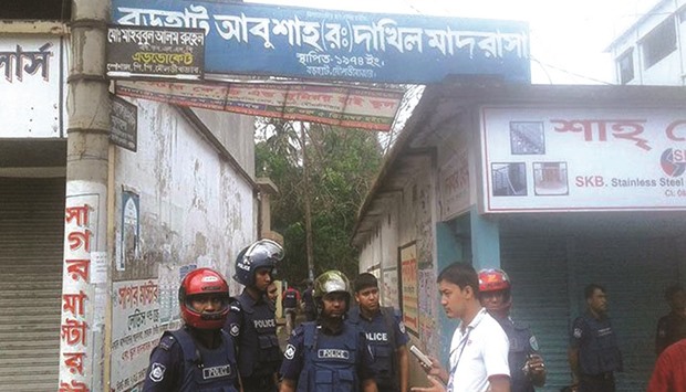 Police seen standing near the militant hideout in Borohat area of Moulvibazar city yesterday.