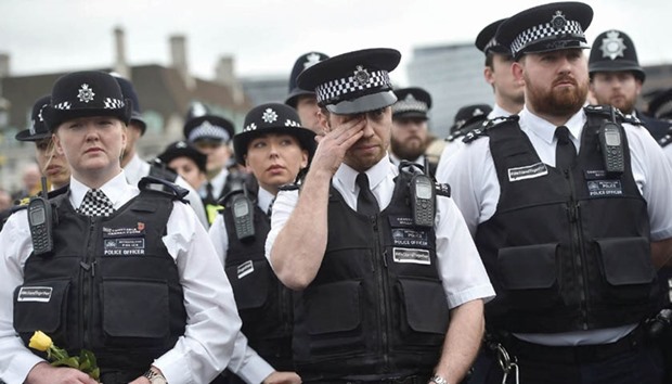 A police officer wipes his face  during an event in London yesterday to mark one week since a man drove his car into pedestrians on Westminster Bridge and then stabbed a police officer.