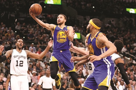 Golden State Warriors point guard Stephen Curry (centre) drives to the basket as San Antonio Spursu2019 LaMarcus Aldridge (left) looks on during the second half at AT&T Center in San Antonio, Texas on Wednesday. (USA TODAY Sports)