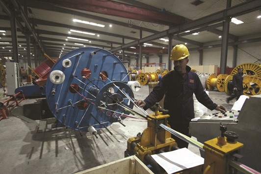 A worker monitors automatic copper wire unit at the Fast Cables plant in Lahore.