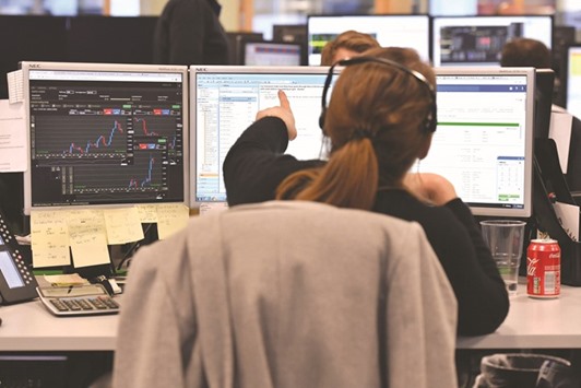 A trader works on the floor at ETX Capital in London (file). The FTSE 100 index edged down 0.06% to 7,369.52 at close yesterday.