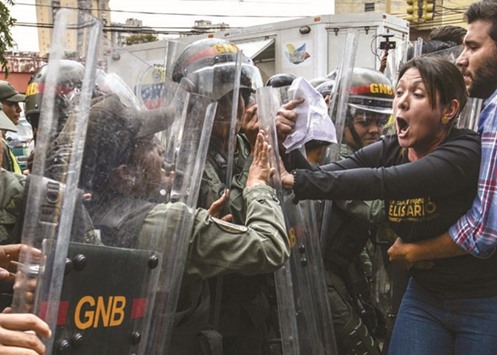 Venezuelan opposition deputy Amelia Belisario scuffles with National Guard personnel in riot gear during a protest yesterday in front of the Supreme Court in Caracas.
