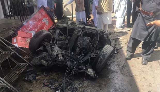 Pakistani security officials and residents gather at the site of a powerful explosion in Parachinar, capital of the Kurram tribal district, on Friday.