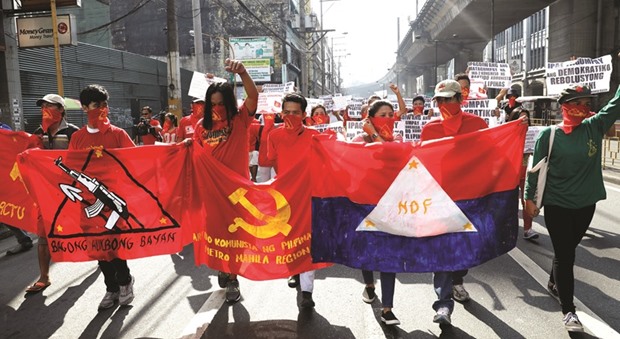 Protesters display banners of underground Communist movements as they march along a street in Manila yesterday.