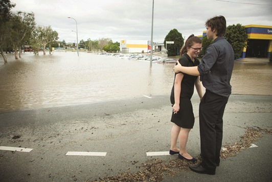 Maddie Skyring is comforted by a companion after discovering her submerged car at the flooded Beenleigh train station carpark yesterday.