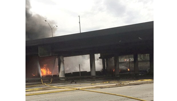 A fire is seen underneath a highway overpass on Interstate 85, before a section of the highway in Atlanta collapsed.