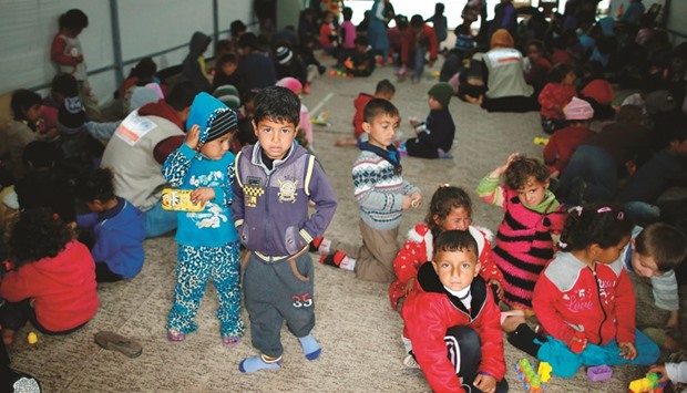 Displaced Iraqi children, who fled Mosul due to the ongoing fighting between government forces and Islamic State (IS) militants, pose for a photo at the Hasan Sham Camp, 30 kilometres east of Mosul, yesterday.