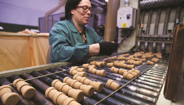 A worker inspects Helix cork stoppers during quality control checks at the Amorim & Irmaos factory in Santa Maria da Feira, Portugal. Eurozone private sector business activity rose at its quickest pace in nearly six years in February.