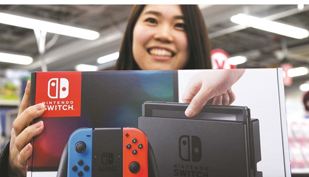 A customer poses with her newly purchased Nintendo Switch game console at a shop in Tokyo yesterday.