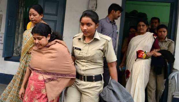 Indian police officials escort Chandana Chakraborty (2R) and Sonali Mondal (2L) from a police station in Jalpaiguri 