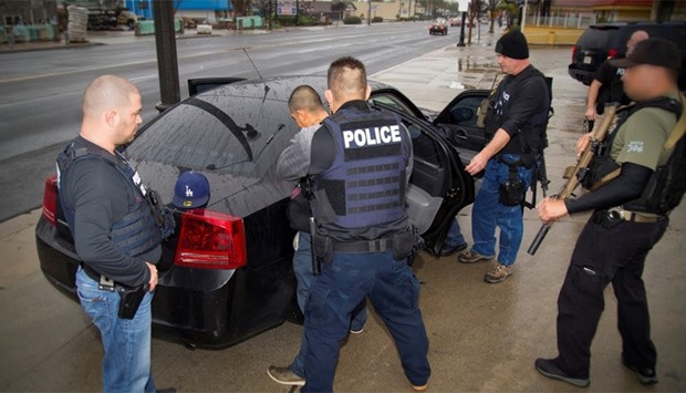 US Immigration and Customs Enforcement officers detain an unauthorized migrant